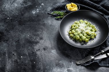 Fesleğen ıspanak soslu ve parmesanlı Gnocchi. İtalyan patates ezmesi. Siyah arka plan. Üst Manzara. Boşluğu kopyala.