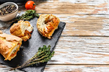 Patlıcan, domates ve peynirle doldurulmuş baget. Lezzetli bir vejetaryen yemeği, lezzetli atıştırmalıklar, ev yapımı sandviç. Gri arka plan. Üst Manzara. Boşluğu kopyala.