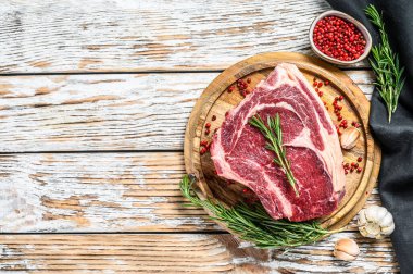 Kemiğe pirzola ya da kovboy bifteği. Çiğ Dallas bifteği. Beyaz ahşap arka plan. Üst Manzara. Boşluğu kopyala.