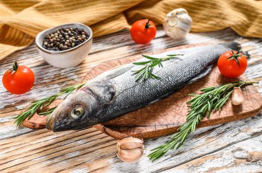 Bitkilerle birlikte taze çiğ deniz levreği. Beyaz arka plan. Üst görünüm.