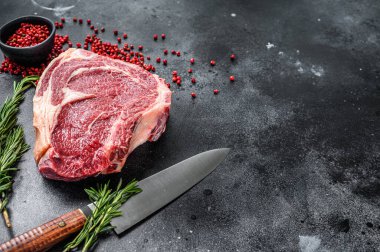 Kemiğe pirzola ya da kovboy bifteği. Çiğ mermer biftek. Siyah arka plan. Üst Manzara. Boşluğu kopyala.