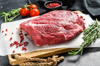 Kesme tahtasındaki çiğ sığır eti. Siyah arka plan. Üst görünüm.