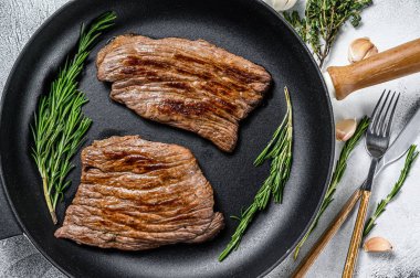 Kızarmış demir ve kanatlı biftekler. Mermer sığır eti. Gri arka plan. Üst görünüm.