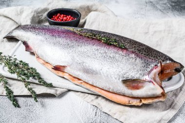 Tuzlu ve kekikli çiğ alabalık. Gri arka plan. Üst görünüm.