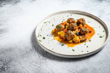 Domates soslu kıymadan yapılmış lezzetli köfteler, eski metal tavada servis ediliyor. Gri arka plan. Üst Manzara. Metin için boşluk.