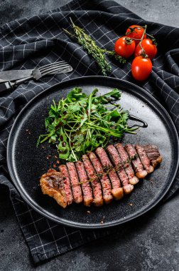 Biftek fileto, roka ile mermer et. Siyah arka plan. Üst görünüm.