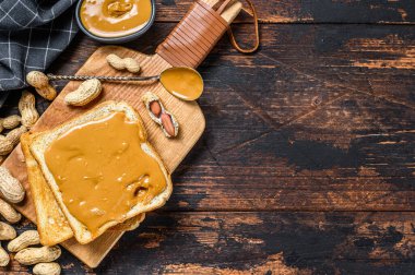 Fıstık ezmeli tost. Karanlık ahşap arka plan. Üst Manzara. Boşluğu kopyala.