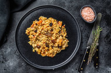 Biftek, kuzu, tavuk, büyük tabaktan yapılmış Özbek pilavı. Karanlık arka plan. Üst görünüm.