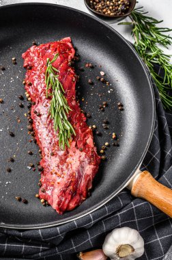 Çiğ mermer biftek, tavada fileto ve yemek malzemeleri. Gri arka plan. Üst görünüm.