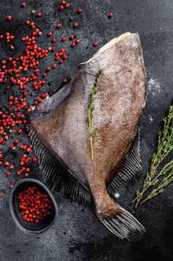 Çiğ taze John Dory balığı, pembe biber ve kekik. Siyah arka plan. Üst görünüm.