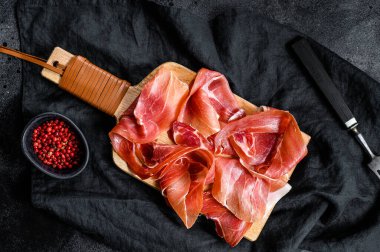 Prosciutto Crudo, İtalyan salamı, parma jambonu. Antipasto tabağı. Siyah arkaplan, üst görünüm