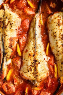 Fırın kabında domatesli maymunbalığı pişirmek. Taze deniz ürünleri. Gri arka plan. Üst görünüm.