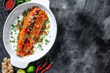 Teriyaki usulü alabalık pişiriyorum. Siyah arka plan. Üst Manzara. Boşluğu kopyala.