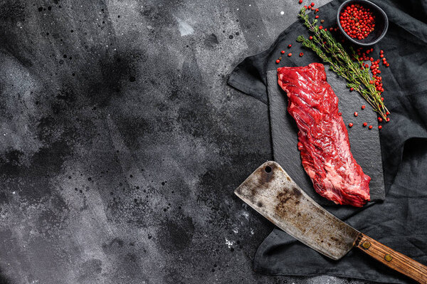 Raw skirt, machete steak with pink pepper and thyme. Black background. Top view. Copy space.