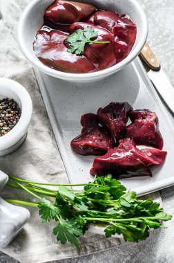 Bir kasede çiğ tavuk ciğeri. Gri arka plan. Üst görünüm