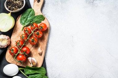 Shakshuka pişirmek için gerekli malzemeler. Yumurta, soğan, sarımsak, domates, biber, ıspanak. Gri arka plan. Üst Manzara. Boşluğu kopyala.