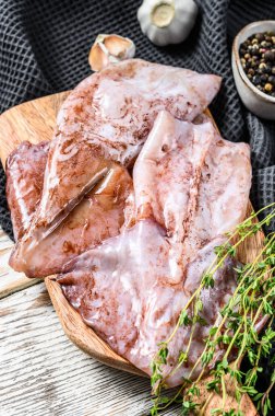 Çiğ mürekkep balığı ve malzemelerin hazırlanması. Beyaz ahşap arka plan. Üst görünüm.