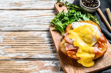 Pastırmalı Brioche sandviç, Benedict usulü yumurta ve Hollandaise sosu. Beyaz arka plan. Üst Manzara. Boşluğu kopyala.