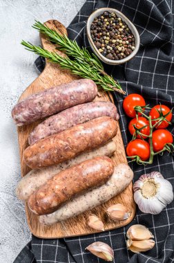 Baharatlı taze domuz eti, sığır eti ve tavuk sosisi. Gri arka plan. Üst görünüm.