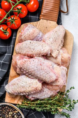 Kesme tahtasında çiğ tavuk kanadı, organik kümes hayvanları. Beyaz arka plan. Üst görünüm.