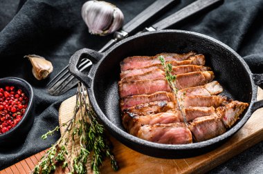 Kemiğe baharat ve otlarla dilimlenmiş domuz pirzolası. Siyah arka plan. Üst görünüm.