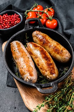 Dökme demir tavada domuz sosisi. Siyah arka plan. Üst görünüm.