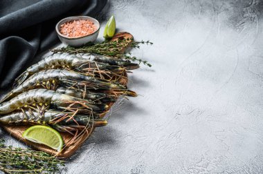 Kara çiğ kaplan karidesleri, kesme tahtasında karidesler. Gri arka plan. Üst Manzara. Boşluğu kopyala.