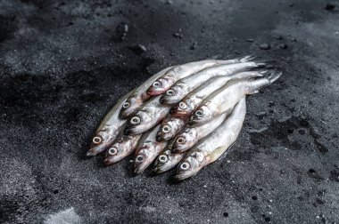 Taze çiğ deniz küçük balıklar kokar. Siyah arka plan. Üst görünüm.