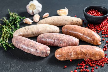 Kekik, sarımsak ve biberle çeşitli taze sosisler. Siyah arka plan. Üst görünüm.