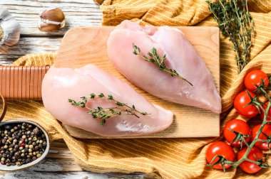 Kekik ve baharatlı tavuk göğsü filetosu pişiriyorum. Beyaz arka plan. Üst görünüm.