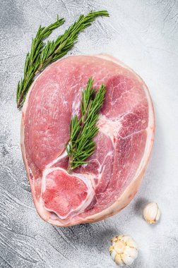 Çiğ domuz budu, masada bacak. Taze çiftlik eti. Gri arka plan. Üst görünüm.