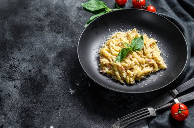 İtalyan usulü makarna. Krema soslu, pastırmalı ve fesleğenli tarif. Hazır risoni. Siyah ahşap arka plan. Üst Manzara. Boşluğu kopyala.