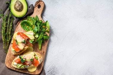 Avokado ve somonlu sağlıklı sandviç. Ispanak ve roka salatası. Beyaz arka plan. Üst Manzara. Boşluğu kopyala.