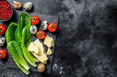 Sezar salatası, marul, domates, yumurta, parmesan, sarımsak, biber. Siyah arka plan. Üst Manzara. Boşluğu kopyala.