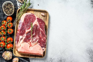 Taze çiğ biftek, baharat ve ahşap kasede otlar. Gri arka plan. Üst Manzara. Boşluğu kopyala.