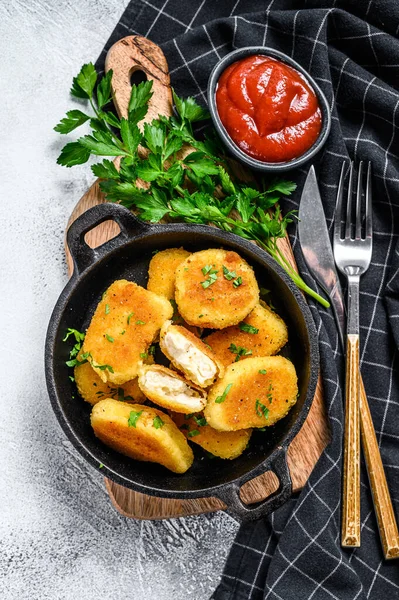 Ketçap ve bitkilerle tavada kızarmış tavuk nugget. Beyaz arka plan. Üst görünüm.