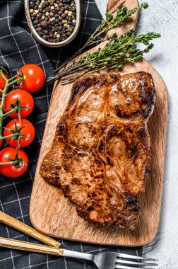 Doğrama tahtasında domuz eti kızartması. Organik et. Gri arka plan. Üst görünüm.