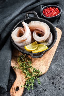 Tavada hake balığı filetosu pişirme tarifi. Siyah arka plan. Üst görünüm.