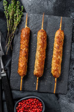 Lula kebabı. Çubukta şiş kebap, kıymalı kıymadan. Siyah arka plan. Üst görünüm.