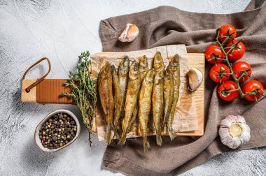 Kızarmış eritilmiş balık. Küçük kızarmış balık. Gri arka plan. Üst görünüm