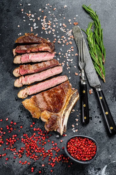 Gegrilde cowboy of ribeye biefstuk met kruiden en specerijen. Zwarte achtergrond. Bovenaanzicht — Stockfoto