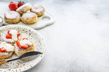 Süzme peynirli krep, şurup, çilekli peynirli börek. Gri arka plan. Üst Manzara. Boşluğu kopyala.