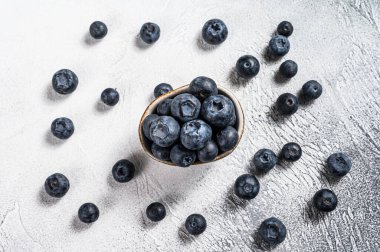 Beyaz bir seramik kasede yaban mersini. Gri arka plan. Üst görünüm.