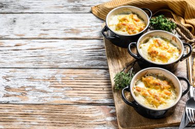 Julienne, ahşap bir masada porsiyon şeklinde tavuk ve peynirle. Beyaz arka plan. Üst Manzara. Boşluğu kopyala.