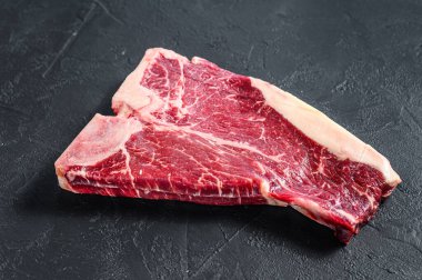 Kalın Raw T-Bone bifteği. Siyah arka plan. Üst görünüm.