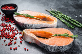 Картина, постер, плакат, фотообои "two fresh raw salmon steaks with pepper and rosemary. black background. top view.", артикул 393318044
