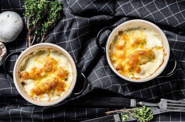 Kil kapta peynirli tavuk ve mantar güveci. Siyah arka plan. Üst görünüm.