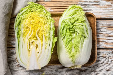 Çin lahanası kesiyorum. Organik sebzeler. Beyaz ahşap arka plan. Üst görünüm.