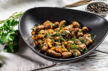 Tavuk ciğeri pişirilmiş kalpleri bir tabakta. Beyaz ahşap arka plan. Üst görünüm.