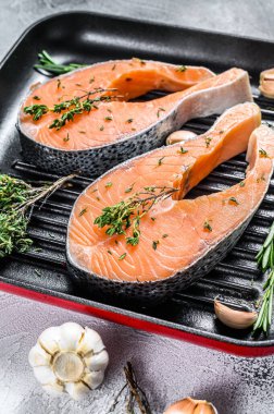 Tavada somon fileto biftek. Çiğ taze balık. Beyaz arka plan. Üst görünüm.